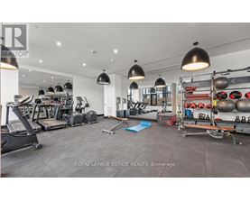 A spacious gym with various exercise equipment and a blue mat on the floor.