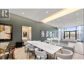 A modern dining room with a long table and chairs.
