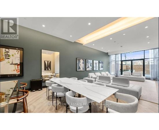 A modern dining room with a long table and chairs.