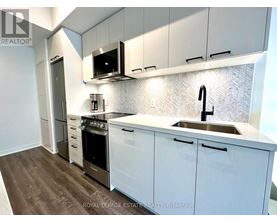 A kitchen with white cabinets and a stainless steel sink.