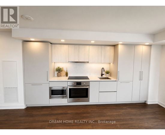 A modern kitchen with white cabinets and stainless steel appliances.