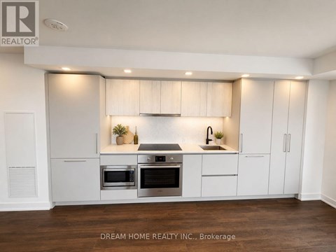 A modern kitchen with white cabinets and stainless steel appliances.