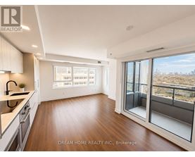 A modern kitchen with wooden floors and a large window overlooking a cityscape.