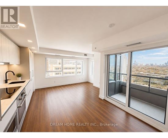A modern kitchen with wooden floors and a large window overlooking a cityscape.