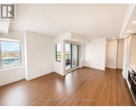 A spacious room with wooden floors and a large window overlooking a cityscape.