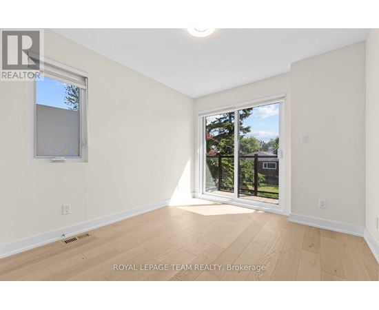 A room with a sliding glass door leading to a backyard.