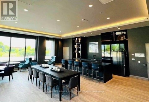 A modern dining room with a long table and chairs.