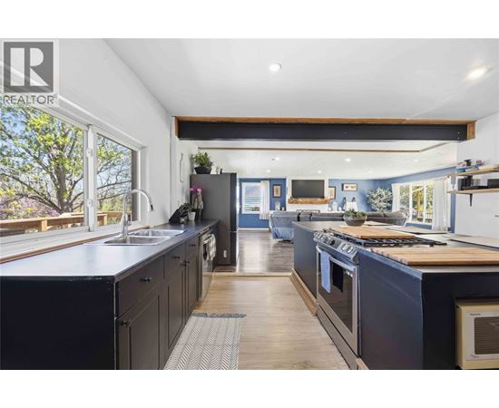 A modern kitchen with dark cabinets and a wooden island.