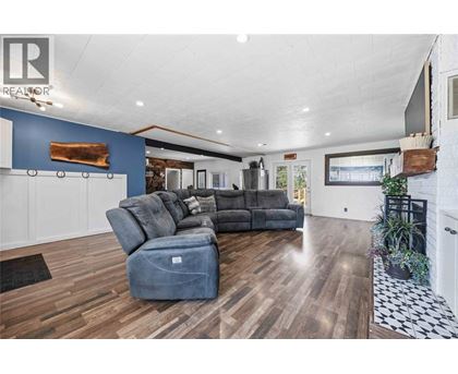 A living room with a grey sofa and a wooden floor.