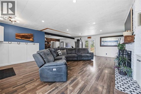 A living room with a grey sofa and a wooden floor.