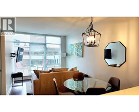 A living room with a couch, chairs, and a dining table.