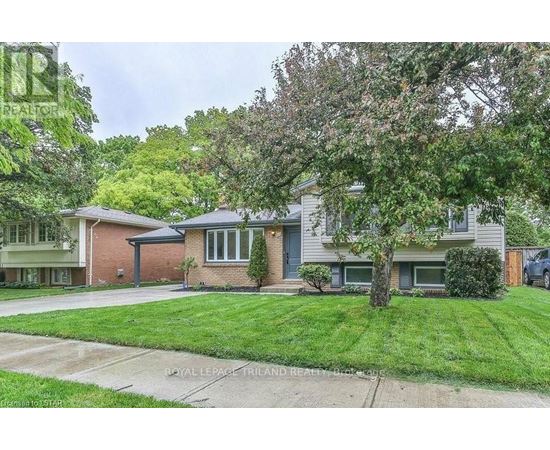 A house with a green lawn and trees in front.