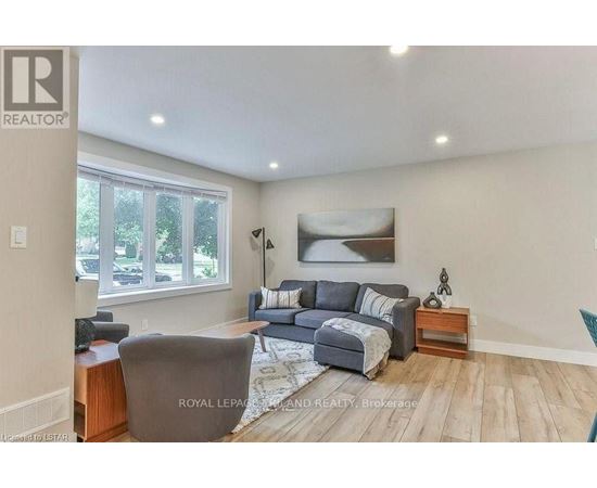 A living room with a grey couch and a wooden side table.