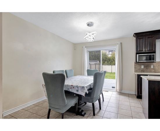 A dining room with a table and chairs.