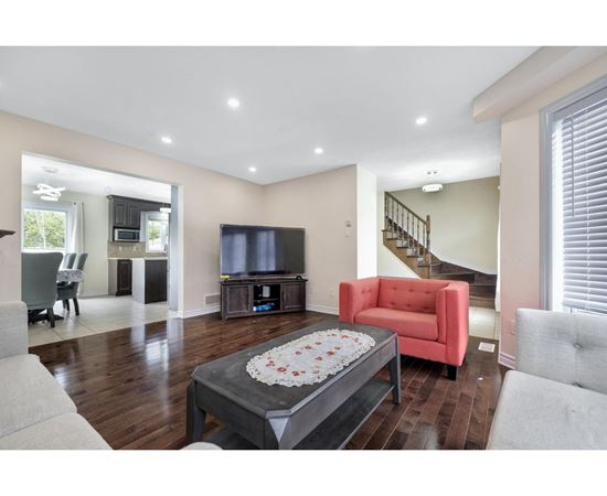 A living room with a red chair and a coffee table in the center.