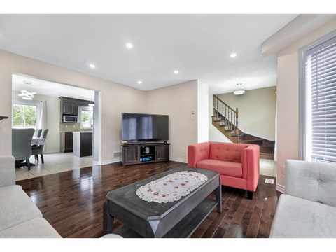 A living room with a red chair and a coffee table in the center.