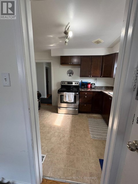 A kitchen with a tile floor and a stove top oven.