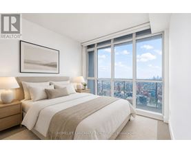 A bedroom with a large bed and a view of the city.