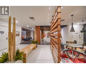 A modern living room with a wooden staircase and a glass table.