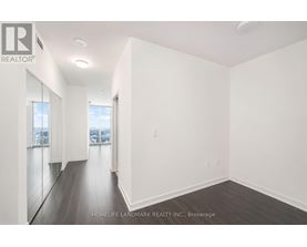 A spacious room with wooden floors and white walls.