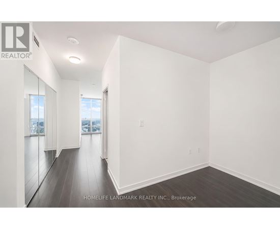 A spacious room with wooden floors and white walls.
