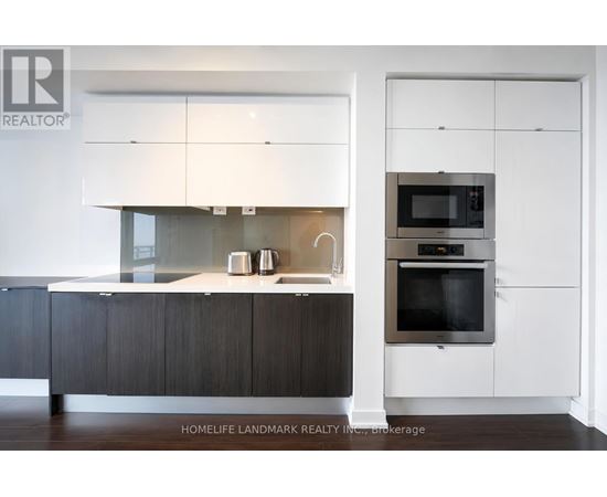 A modern kitchen with dark wood cabinets and white appliances.