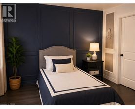 A bedroom with a large bed and a nightstand with a lamp.