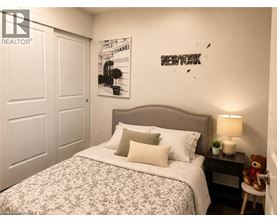 A bedroom with a bed, a teddy bear, and a lamp.