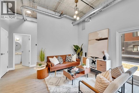 A living room with a brown couch, a coffee table, and a painting on the wall.