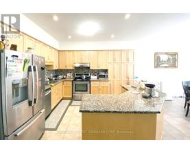 A kitchen with a granite counter top and wooden cabinets.