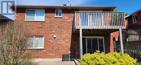 A red brick house with a balcony and a window.
