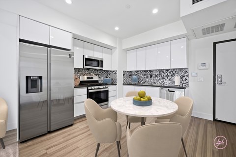 A modern kitchen with a dining table set for four.