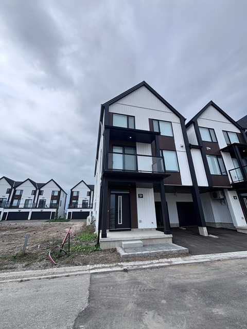 A modern two-story residential building with a black and white exterior.