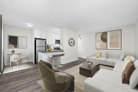 A modern living room with a grey sofa, a coffee table, and a dining table with chairs.
