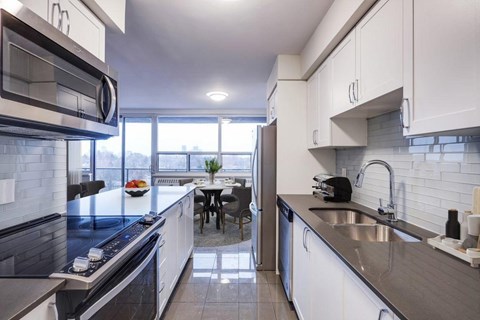 A modern kitchen with a dining table and chairs in the background.