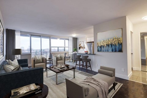 A living room with a large painting on the wall and a view of the city outside the window.