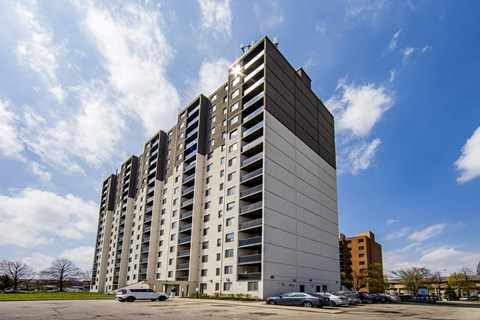 A large, modern building with a parking lot in front.