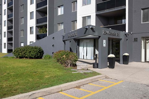 The entrance to a building with a black awning and a sign that reads "The Crest".