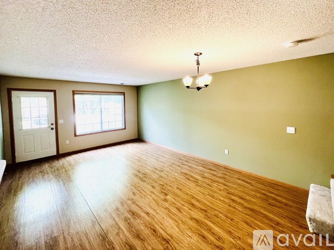A room with wooden flooring and a light fixture on the ceiling.