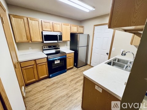A kitchen with wooden cabinets and a white counter.