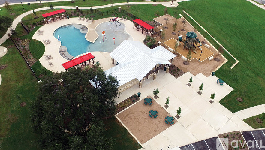 A playground with a slide, swings, and a tree.