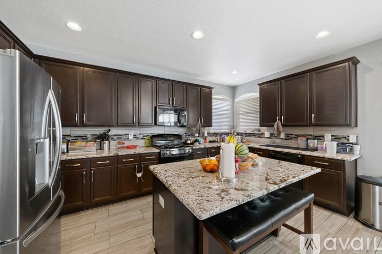 A kitchen with brown cabinets and a granite countertop.