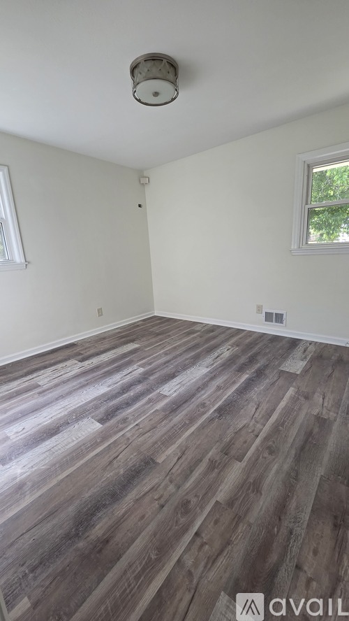 A room with wooden flooring and a window.