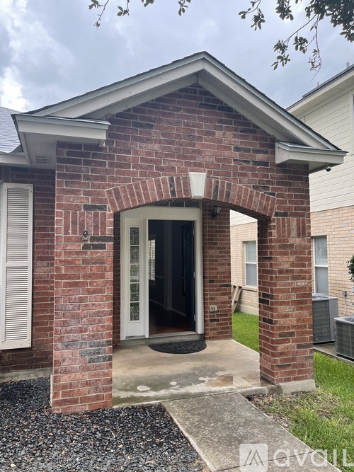 A brick house with a white door and a small porch.