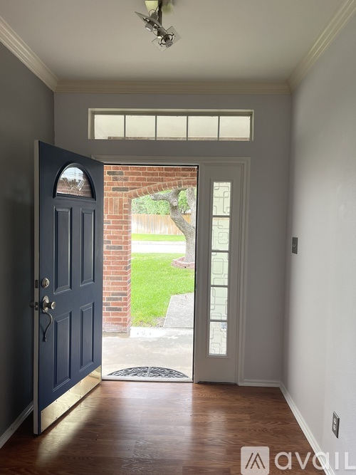 A hallway with a dark blue door and a light grey wall.