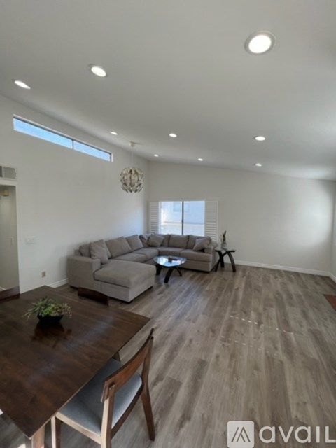 A living room with a wooden table and grey couches.