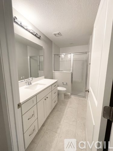 A bathroom with a sink, toilet, and shower.