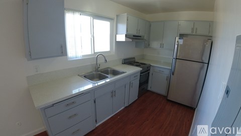 A kitchen with a sink, stove, and refrigerator.