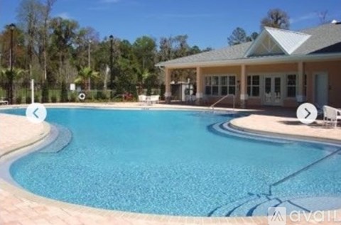 A large swimming pool with a building in the background.
