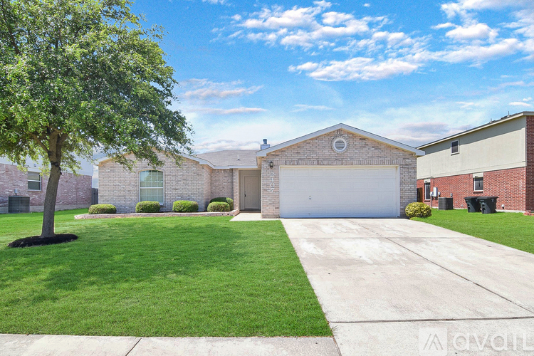 A house with a garage and a tree in the front yard.
